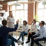 work colleagues sitting in a circle discussing something.