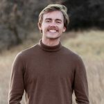Photo of Ethan Webb with moustache and wearing brown turtleneck